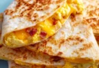Delicious breakfast quesadilla filled with eggs, cheese, and vegetables
