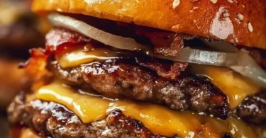 Delicious Crack Burger with toppings and side fries on a wooden table.
