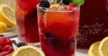 A refreshing glass of homemade triple berry lemonade with fresh berries.