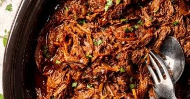 Delicious homemade beef barbacoa served in a bowl with fresh toppings