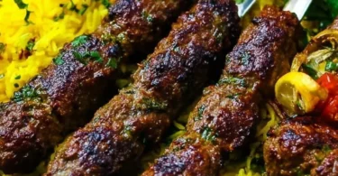 Plate of juicy Middle Eastern kebabs garnished with fresh herbs and vegetables
