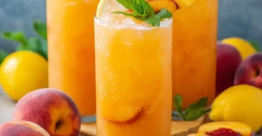 A refreshing glass of homemade Peach Lemonade garnished with fresh peach slices.