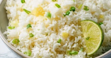 Delicious pineapple rice served in a bowl garnished with fresh herbs.